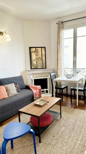 un salon avec un canapé et une table dans l'établissement Le Patio - Joli logement - Wifi - Disney & Paris, à Champigny-sur-Marne