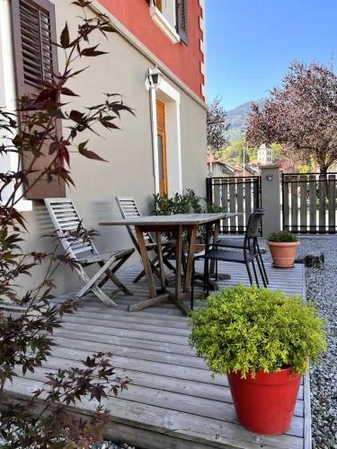 une terrasse en bois avec une table et des chaises dessus dans l'établissement Duplex Sallanches Centre Ville, à Sallanches