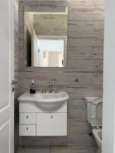 a bathroom with a sink and a mirror and a toilet at Departamento en Bragado B in Bragado