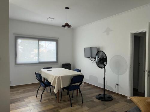 een witte kamer met een tafel en stoelen en een ventilator bij Departamento en Bragado B in Bragado