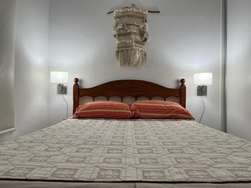 een slaapkamer met een groot bed met 2 lampen bij Departamento en Bragado B in Bragado