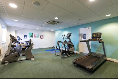 a gym with treadmills and ellipticals in a room at 39 Woodland Walk in Pevensey