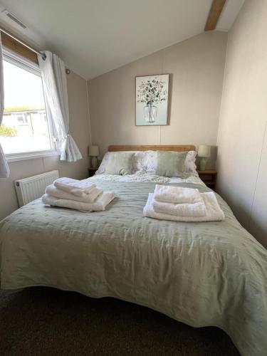 um quarto com uma cama com duas toalhas em 39 Woodland Walk em Pevensey