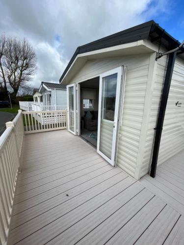 a large wooden deck next to a house at 39 Woodland Walk in Pevensey