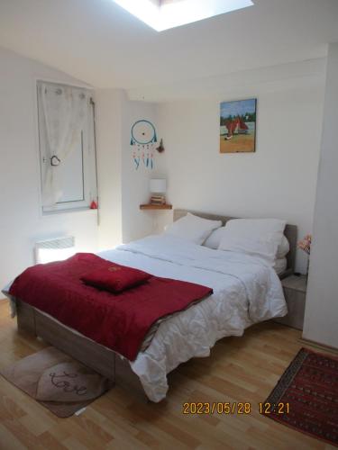 a bedroom with a large bed with a red blanket at location située à 300 mètres de la thalasso de Pornic et des plages in Pornic