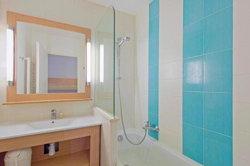 a bathroom with a sink and a glass shower at Domaine Valescure Appartement 1 ou 2 pieces vue jardin ou piscine in Saint-Raphaël