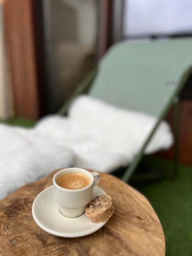 - une tasse de café et un biscuit sur une table dans l'établissement Les Tanières de Montgenèvre - Studio Dama - neuf 4p avec terrasse vue imprenable, à Montgenèvre