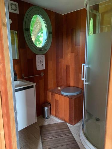 ein kleines Bad mit einem Waschbecken und einem Fenster in der Unterkunft Le chalet de la Champagne in Saint-Molf