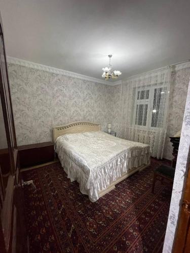 - une chambre avec un lit dans une pièce avec du papier peint dans l'établissement 3х комнатная квартира, à Samarcande