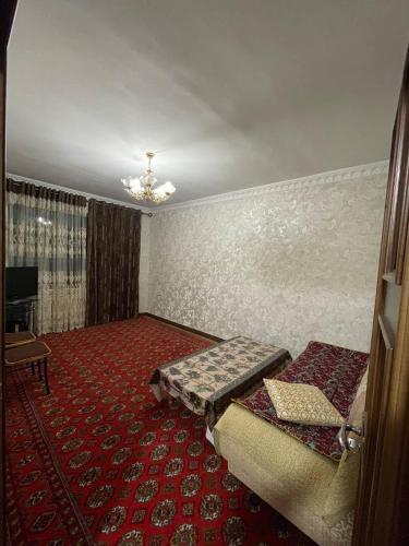 Cette chambre comprend 2 lits et un tapis rouge. dans l'établissement 3х комнатная квартира, à Samarcande