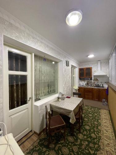 une cuisine avec une table et des chaises ainsi qu'une fenêtre dans l'établissement 3х комнатная квартира, à Samarcande
