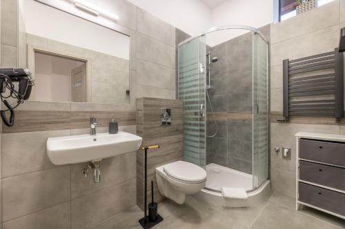 a bathroom with a toilet and a sink and a shower at Apartamenty Bełska Centrum in Ustrzyki Dolne