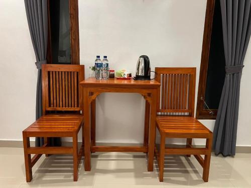 a wooden table with two chairs and a telephone on it at Bali Cottages Lake View in Kintamani