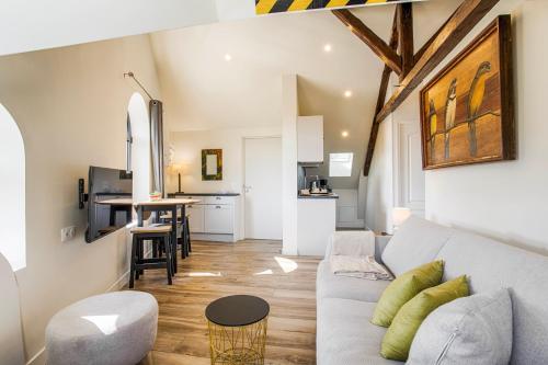 a living room with a couch and a kitchen at Beau L.O.F.T. sous les toits - vue sur mer 2 à 4 personnes - Résidence la Vague in Houlgate