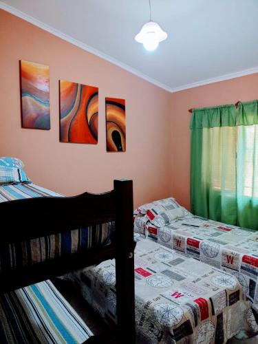 two beds in a room with paintings on the wall at Casa Arenales in Almafuerte