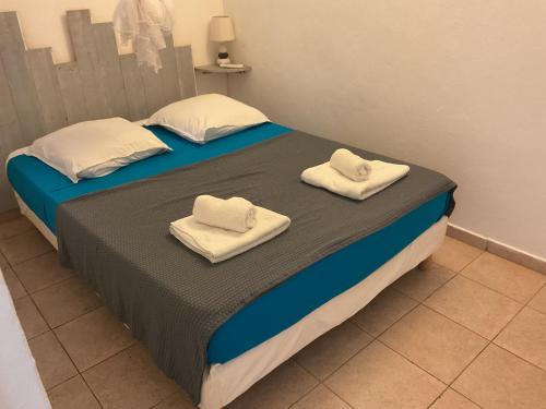 a bedroom with a bed with towels on it at RESIDENCE BLEU MARINE (Appartement Bleu Océan) in Le Gosier