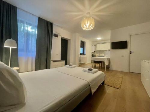 - une chambre avec un grand lit blanc et une table dans l'établissement Sky Residence Airport Otopeni no 4, à Otopeni