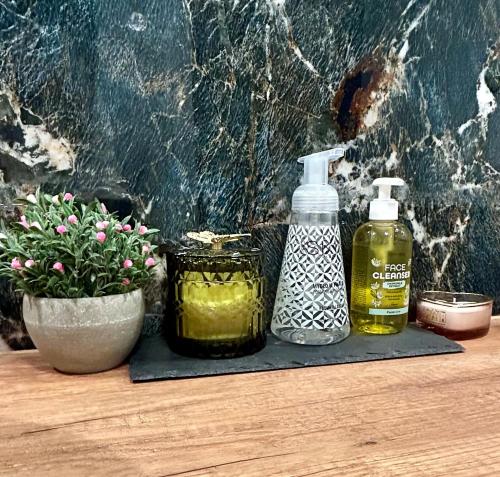 two bottles of oil and a plant on a table at Premium Exclusive Suite in Nowy Dwór Mazowiecki