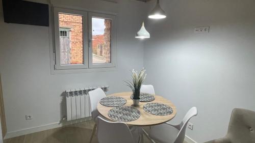 a dining room with a wooden table and white chairs at APARTAMENTOS AREKORATAS 255 y 256 in Muro de Ágreda