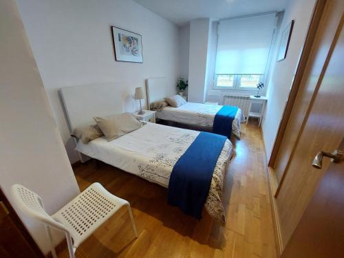 a bedroom with two beds and a window at Tiviti playa ribadesella in Ribadesella