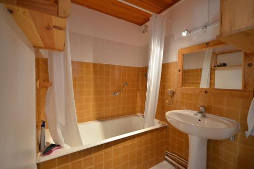 La salle de bains est pourvue d'un lavabo et d'une baignoire. dans l'établissement Duplex 59m2 - proche centre - balcon plein sud, à Corrençon-en-Vercors