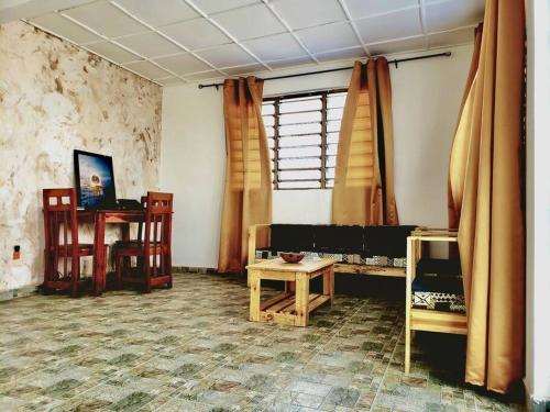 a room with a table and chairs and a window at 2 chambres dans un appartement avec vue sur la mer in Cotonou