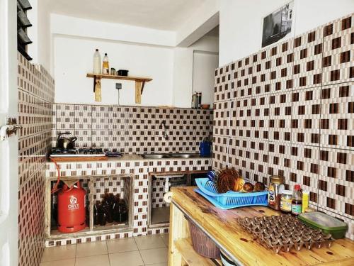 a kitchen with white tiled walls and a counter top at 2 chambres dans un appartement avec vue sur la mer in Cotonou