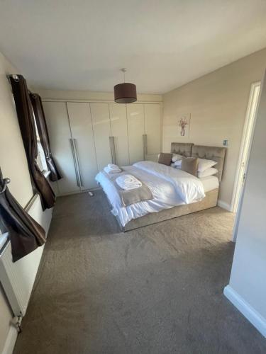 a bedroom with a large bed with white sheets and pillows at The Peaceful Place in Cheshunt