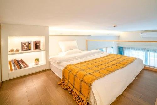 a bedroom with a bed with a yellow blanket on it at Guangzhou YuXiang Apartment - Guangzhou Pazhou International Convention and Exhibition Center in Guangzhou