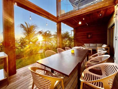 a dining room with a table and chairs on a deck at A Beachfront Haven - Ocean Point B2 in Pointe aux Piments