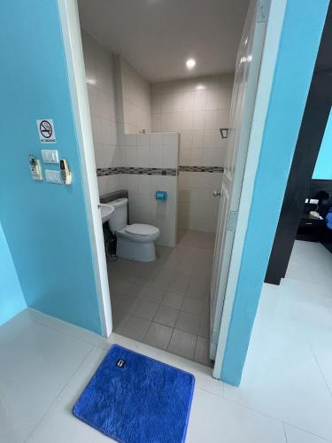 a bathroom with a toilet and a blue rug at GazStation in Kata Beach