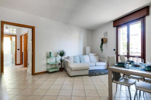 een woonkamer met een witte bank en een tafel bij Residenza Quadrifoglio in Cesena