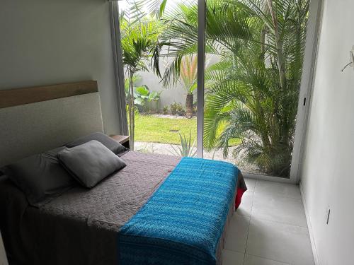 a bedroom with a bed and a large window at Departamento exclusivo de lujo jardín y terraza gh3 in Guadalajara