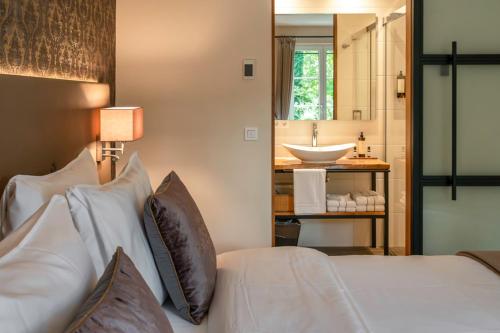 a bedroom with a bed and a bathroom with a sink at KerkHotel Biervliet in Biervliet