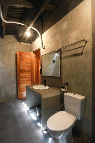 a bathroom with a toilet and a sink and a mirror at Marika Resort in Badian