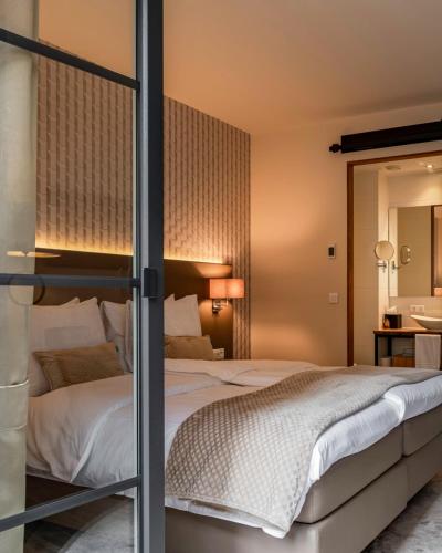 a bedroom with a bed and a mirror at KerkHotel Biervliet in Biervliet