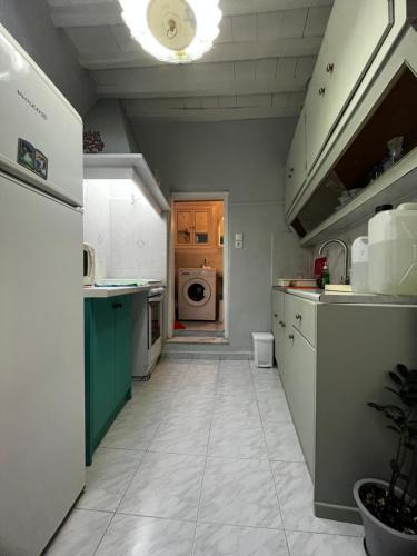 a kitchen with a sink and a washing machine at Kioura's home in Ano Syros