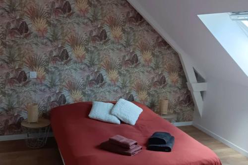 ein Schlafzimmer mit einem roten Bett mit Handtüchern darauf in der Unterkunft Le Goh Reste, agréable maison de campagne in Locmaria-Grand-Champ