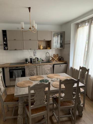 une cuisine avec une table et des chaises et une cuisine avec un évier dans l'établissement Maison le cap, à Plouhinec