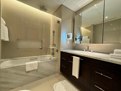 W łazience znajduje się wanna, umywalka i lustro. w obiekcie Amazing Sea view w Dubaju