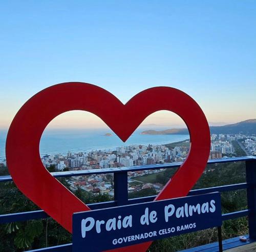 a heart sign with a city in the background at Paraíso em Palmas com Piscina - 3 min do mar a pé! in Governador Celso Ramos