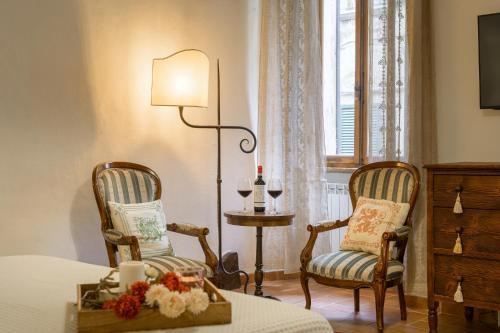 - une chambre avec deux chaises, une table et une lampe dans l'établissement Holiday Home Adelaide, à Pienza