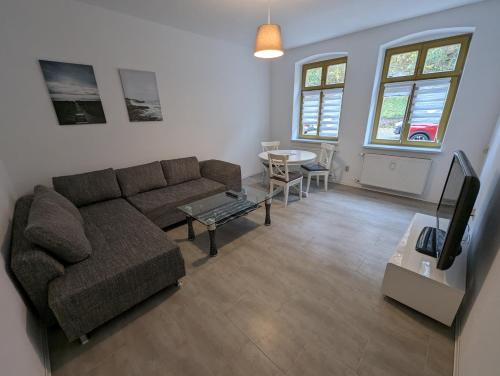 a living room with a couch and a table at Burg Stargard Zwei Zimmer Wohnung in Burg Stargard