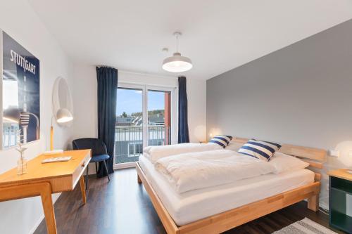 1 dormitorio con cama, escritorio y ventana en Design-Apartment - Küche - Dachterrasse - zentral, en Leinfelden-Echterdingen