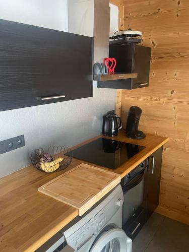 uma cozinha com uma bancada com um fogão em Cosy Mountain _ free park em Montgenèvre