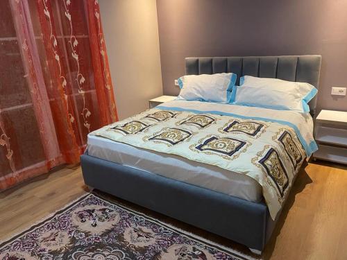 1 dormitorio con 1 cama grande con alfombra en Olympic Tirana en Tirana