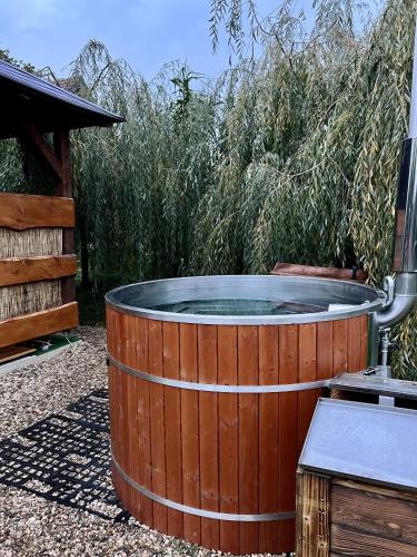 a wooden hot tub in a yard next to a bush at Domek u rybníka in Schloss Bösig