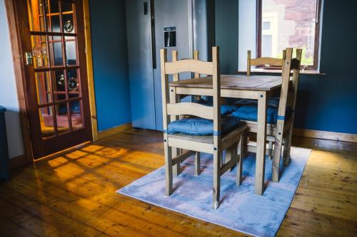 a dining room table with two chairs and a wooden table at 3-bedroom house for outdoor holidays in Alyth