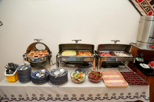 een buffet met veel verschillende soorten eten op een tafel bij Hotel RAYHON BOUTIQUE in Bukhara