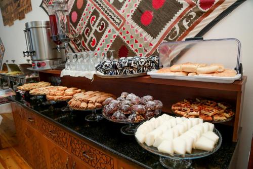 een buffet met verschillende soorten zoete deegwaren en desserts bij Hotel RAYHON BOUTIQUE in Bukhara